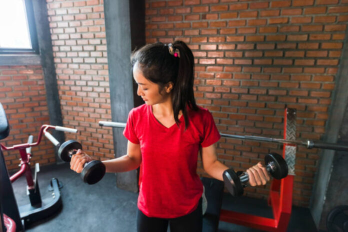 Picture cute of asian woman exercising building muscles in the gym, concept of healthy lifestyle
